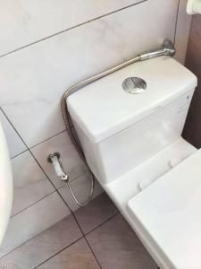 a white bathroom with a hose hooked up to a toilet at 1601 SKS MidValley Terminal bus NetflixWifi By STAY in Johor Bahru