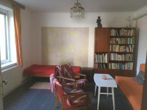 Chalupa Žofka في Brod nad Dyjí: غرفة معيشة مع طاولة وكراسي ورف كتاب
