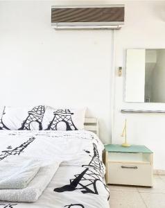 Un dormitorio con una cama en blanco y negro y un espejo en The SunSet 005, en Klorakas