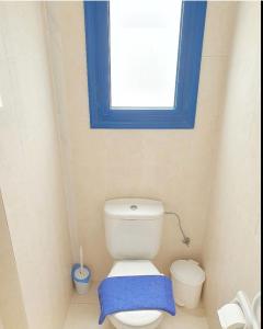 baño con aseo y ventana azul en The SunSet 005, en Klorakas