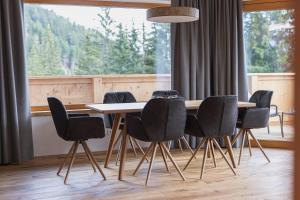 uma sala de jantar com uma mesa e cadeiras em frente a uma janela em Puitalm - Natur I Apart I Hotel em Arzl im Pitztal