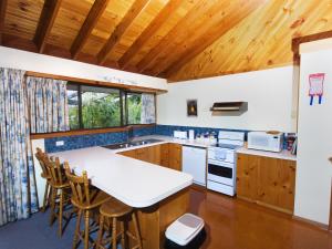 a kitchen with a white counter top and wooden cabinets at Derwent Vista in Austins Ferry