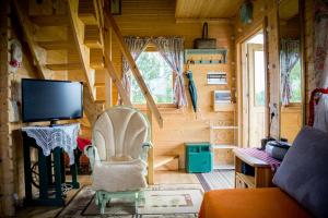 a room with a tv and a chair in a cabin at Magia Krutyni in Krutyń