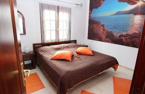 ein Schlafzimmer mit einem Bett mit zwei orangefarbenen Kissen in der Unterkunft Studio Paraiso in Playa Blanca