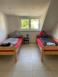 um quarto com duas camas e uma cadeira em Ferienhaus Weitblick Sankt Wendel em Sankt Wendel