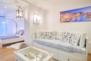 Apartmán Casia في جيسينيك: غرفة معيشة بيضاء مع أريكة وغرفة نوم