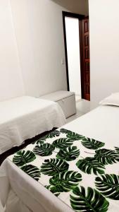 a bed with a green and white blanket on it at Apartamentos Juliel in Morro de São Paulo