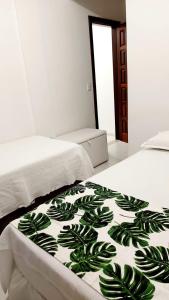 Una cama con una manta verde y blanca. en Apartamentos Juliel, en Morro de São Paulo