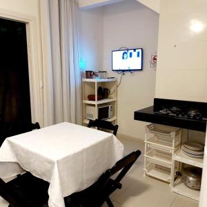 a white room with a table and a tv in it at Apartamentos Juliel in Morro de São Paulo