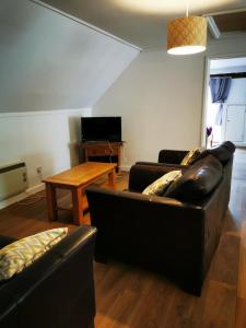 a living room with two leather couches and a table at Nice big 2 double bedroom Apartment in the Town in Newquay
