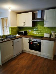 a kitchen with white cabinets and a black oven at Nice big 2 double bedroom Apartment in the Town in Newquay
