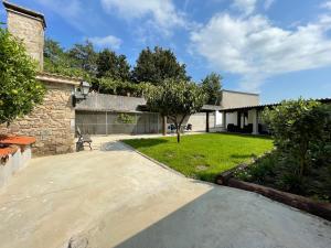 a driveway leading to a house with a yard at Hostel & Rooms Casa Maia in Padrón