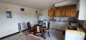 Una cocina con mesa y sillas y un refrigerador. en Malfranza Apartments, en Bridgetown
