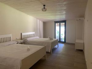 1 dormitorio con 2 camas y ventana en Hostel & Rooms Casa Maia, en Padrón