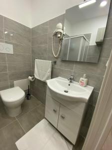 a bathroom with a white sink and a toilet at Si Viaggiare Apartments in Partinico
