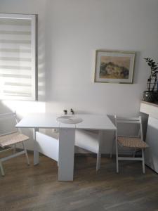 una mesa blanca y 2 sillas en una habitación en Apartman Regina, en Užice