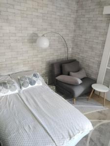 een slaapkamer met een bed en een stoel bij Apartman Regina in Užice