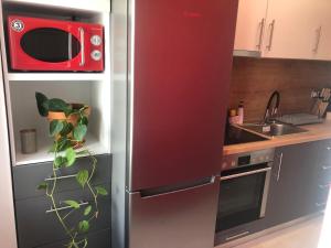 a refrigerator in a kitchen with a red microwave at ROYAL RED SUITE NO 1, PIRAEUS PORT in Piraeus