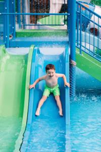 a young boy sliding down a water slide at Westhills Cottage Town & Spa in Bukovel