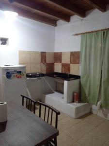 cocina con fogones, fregadero y mesa en Departamentos Sarmiento 3, en San Luis