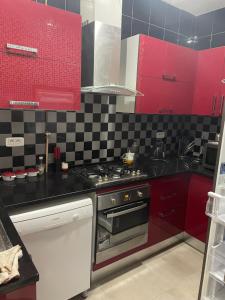 a kitchen with red cabinets and a stove at Appartemet haut standing in Tunis