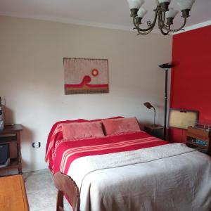 1 dormitorio con 1 cama con manta roja en Habitación de huéspedes con entrada independiente en Concordia