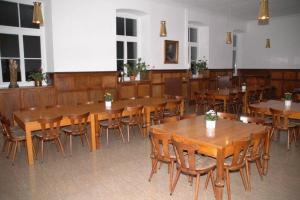 een grote eetkamer met houten tafels en stoelen bij Nikolauskloster in Jüchen
