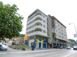 un edificio all'angolo di una strada con una freccia gialla di Apartman Regina a Užice
