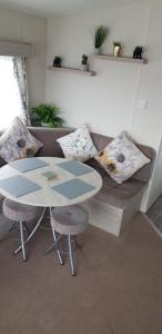 a living room with a table and a couch at The selsey retreat in Selsey