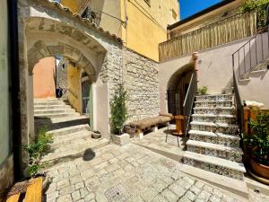 eine Gasse mit Steintreppe und ein Gebäude mit Bogen in der Unterkunft Cuturissi Hospitality & Wellnees in Ragusa