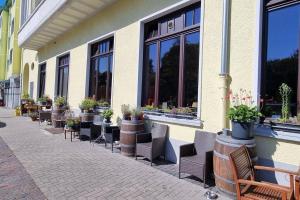 a row of chairs and potted plants on the side of a building at Strandappartement 2 Minuten vom Südstrand in Wilhelmshaven