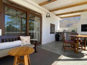 ein Wohnzimmer mit Sofa und Tisch in der Unterkunft 360on62 Farm Cottages in Montagu