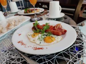 a plate of food with eggs and sausage on a table at Ledumo Guest lodge in eMalahleni