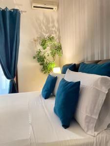 a bed with blue and white pillows on it at Suite room in Aversa