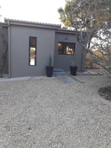 a house with a gravel yard in front of it at Palahala in Marloth Park