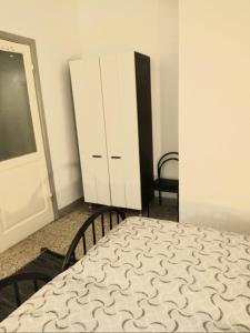 1 dormitorio con 1 cama y armario blanco en CINQUE TERRE HOUSE OF THE PORT with PARKING, en La Spezia