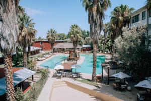 an overhead view of a resort pool with palm trees at Hotel Puesta del Sol in San Rafael
