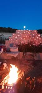 a fire pit on a beach at night with lights at The Annex Rocket cottage in Sidestrand