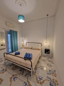 a bedroom with a bed with blue pillows on it at Solis Domus Oriens in Ostuni