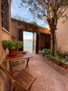 a patio with a wooden table and a bench at Al Ponte Lungo - Giudecca in Venice