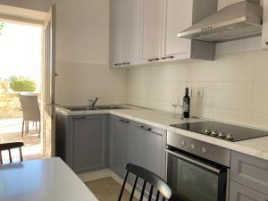 a kitchen with a sink and a stove top oven at Apartment Sea View in Preko