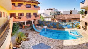 an image of a swimming pool in the middle of a building at Peruíbe Suíte Flat Hotel in Peruíbe