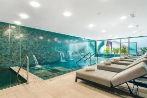 uma grande piscina com um sofá num quarto em Casas Pepe Apartments & Spa- Adults Only em Playa del Inglés