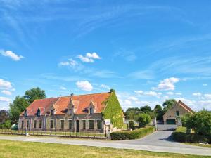 a large house with a red roof on a road at Vakantiehoeve Walleboom in Lo-Reninge