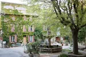 a courtyard in front of a building with a fountain at Spacious stylish Provencal house with terrace in Saignon