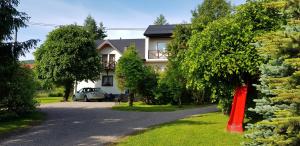 a house with a car parked in the driveway at Wygodne Spanie in Cisna