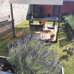 un jardín con flores púrpuras y un patio en Affittacamere Il Tiro a Segno en Norcia