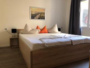 a bedroom with a bed with orange and white pillows at Appartements Antunovic in Povljana