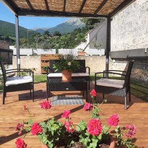 un patio con 2 sillas y una mesa con flores en Affittacamere Il Tiro a Segno en Norcia