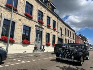 un viejo coche negro estacionado frente a un edificio en Eigenheimer B&B, en Simpelveld